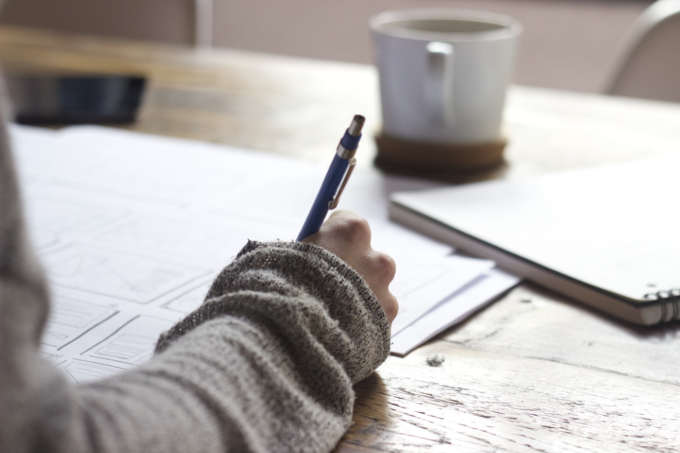 Hands writing notes — analogue capture before digital review